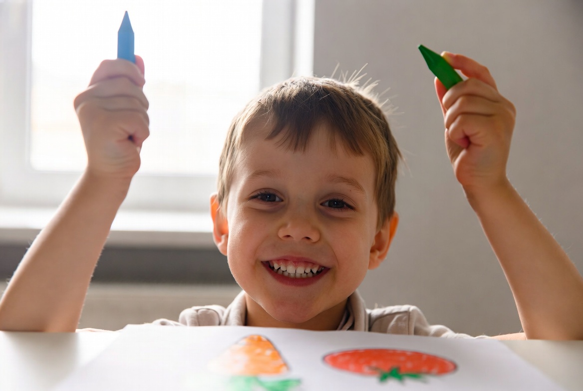 Happy child coloring vegetables