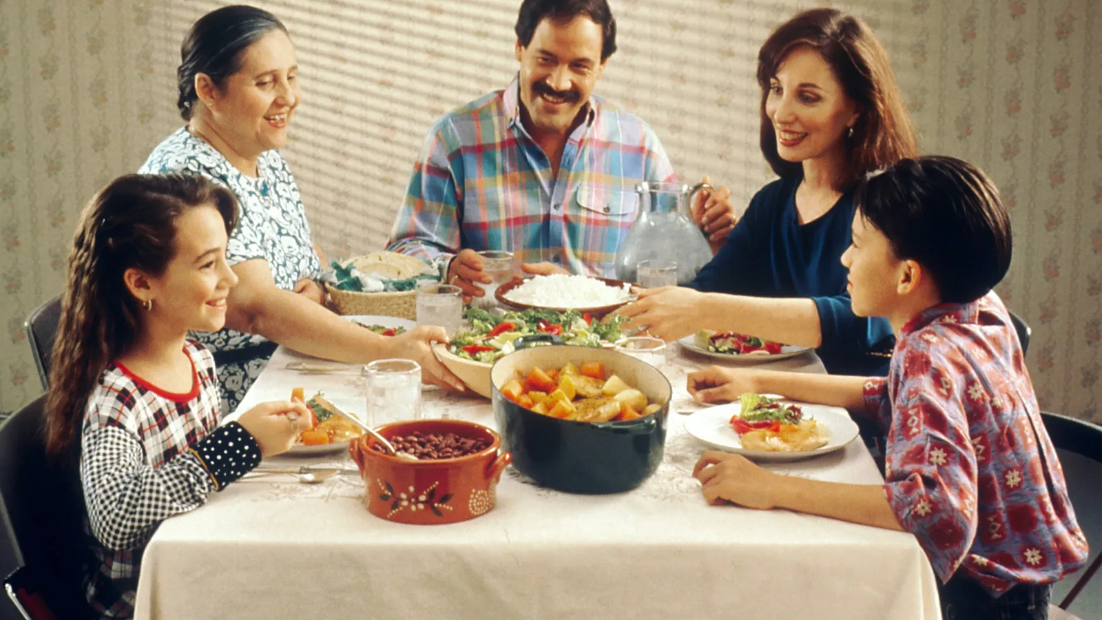 A family with grandparents, parents and two children sharing a home-cooked meal around a dining table